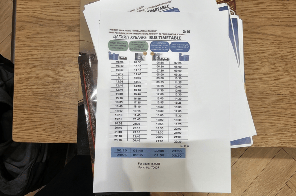 Printed bus timetable showing departure times from an airport to a city square, with various time slots listed.